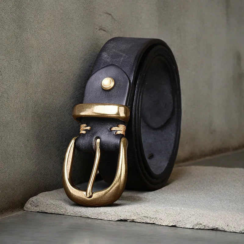 Men's black casual leather belt with copper pin buckle on a jeans background.