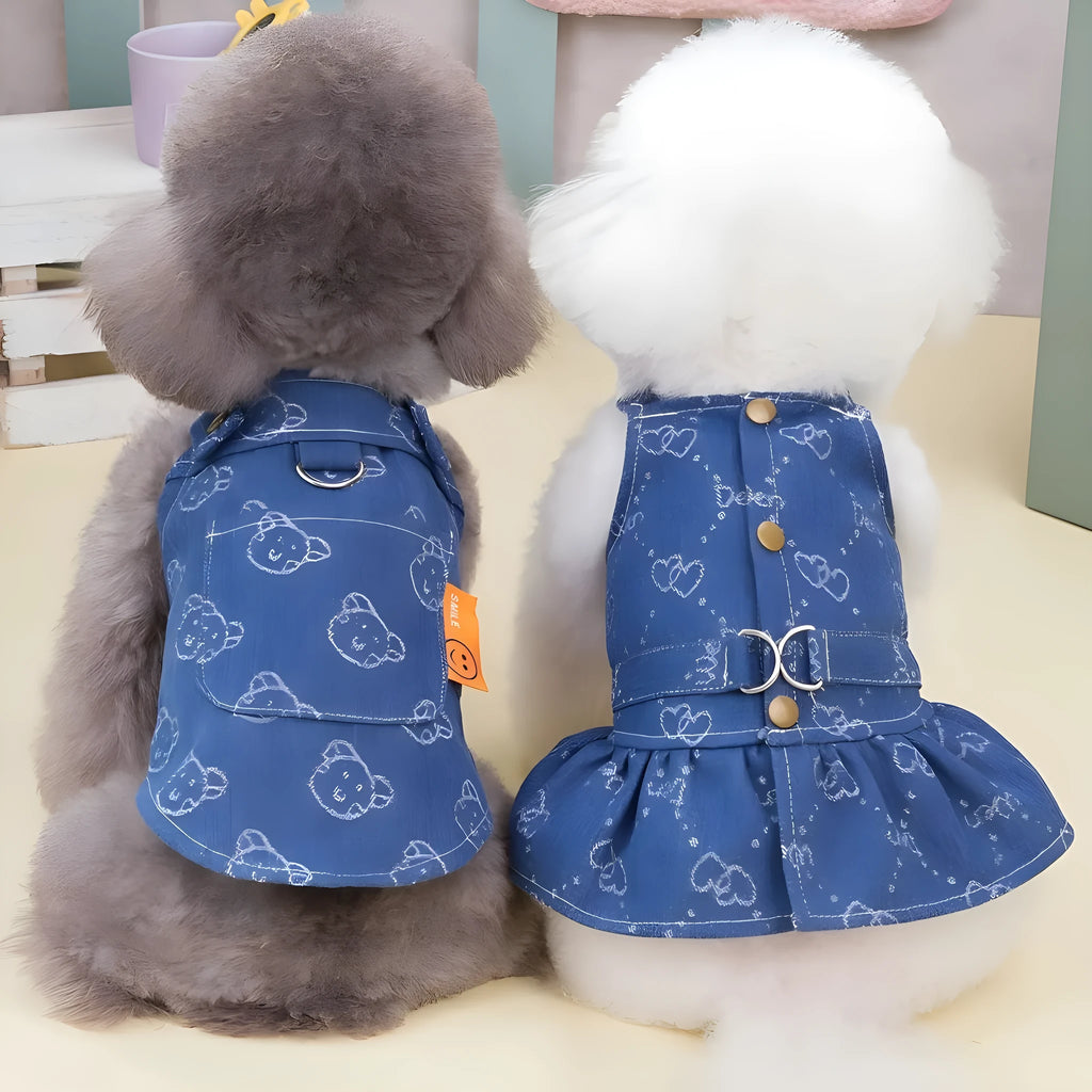 Small white dog wearing a light blue denim princess dress with a frilled skirt.