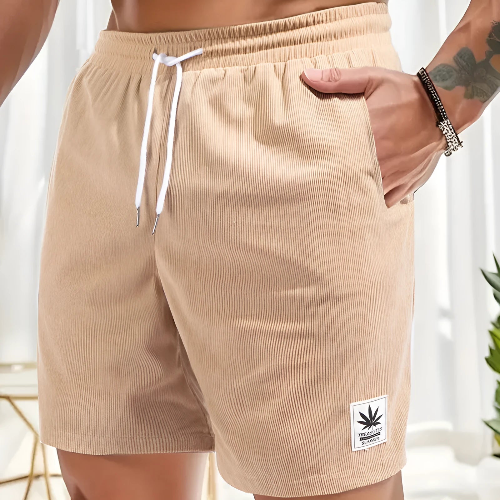 Man wearing grey straight leg drawstring summer shorts made from elastic fabric.