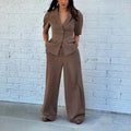 Brown men's slim fit two-piece polyester suit with long sleeves and trousers on a hanger.