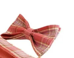Plaid fabric dog collar, leash, bow, and vest four-piece accessory set on a white background.