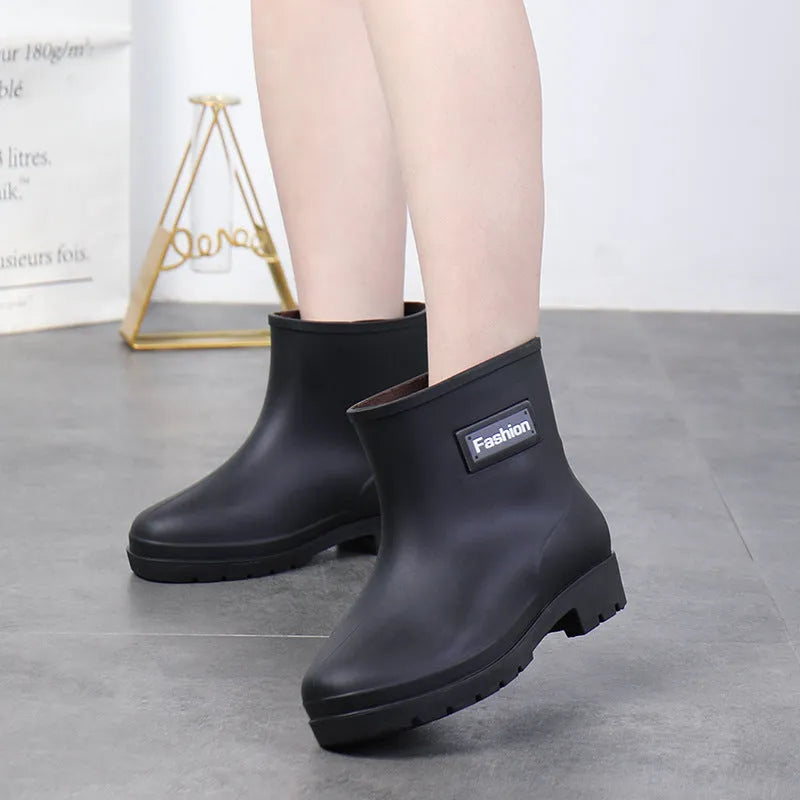Women's black mid-calf rain boot made of PVC with a low heel.
