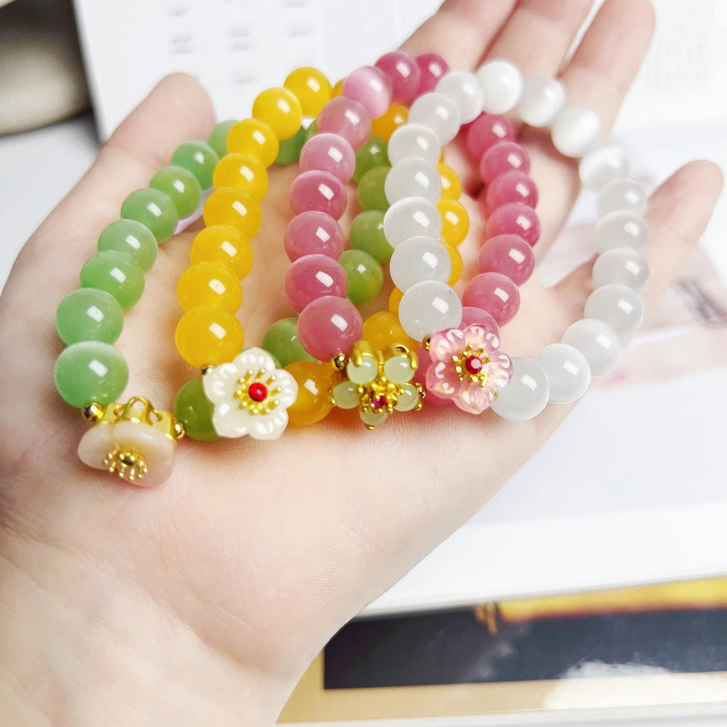 Handmade glass bead bracelet with flower design for women in yellow, pink, white, or green.