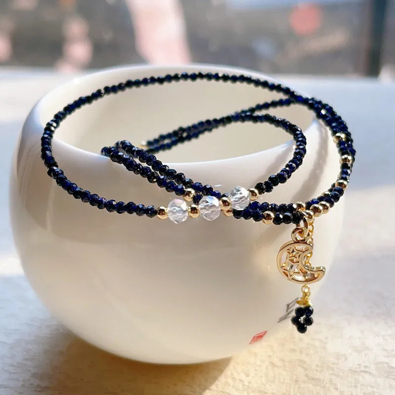 Women's multi-layer bracelet made of blue sand stone with three rings and gold-coloured accents.