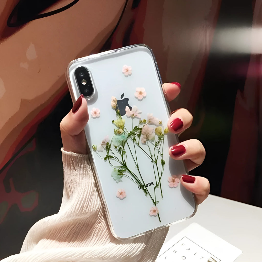 Clear TPU iPhone case with preserved pink dried flowers visible through transparent back cover