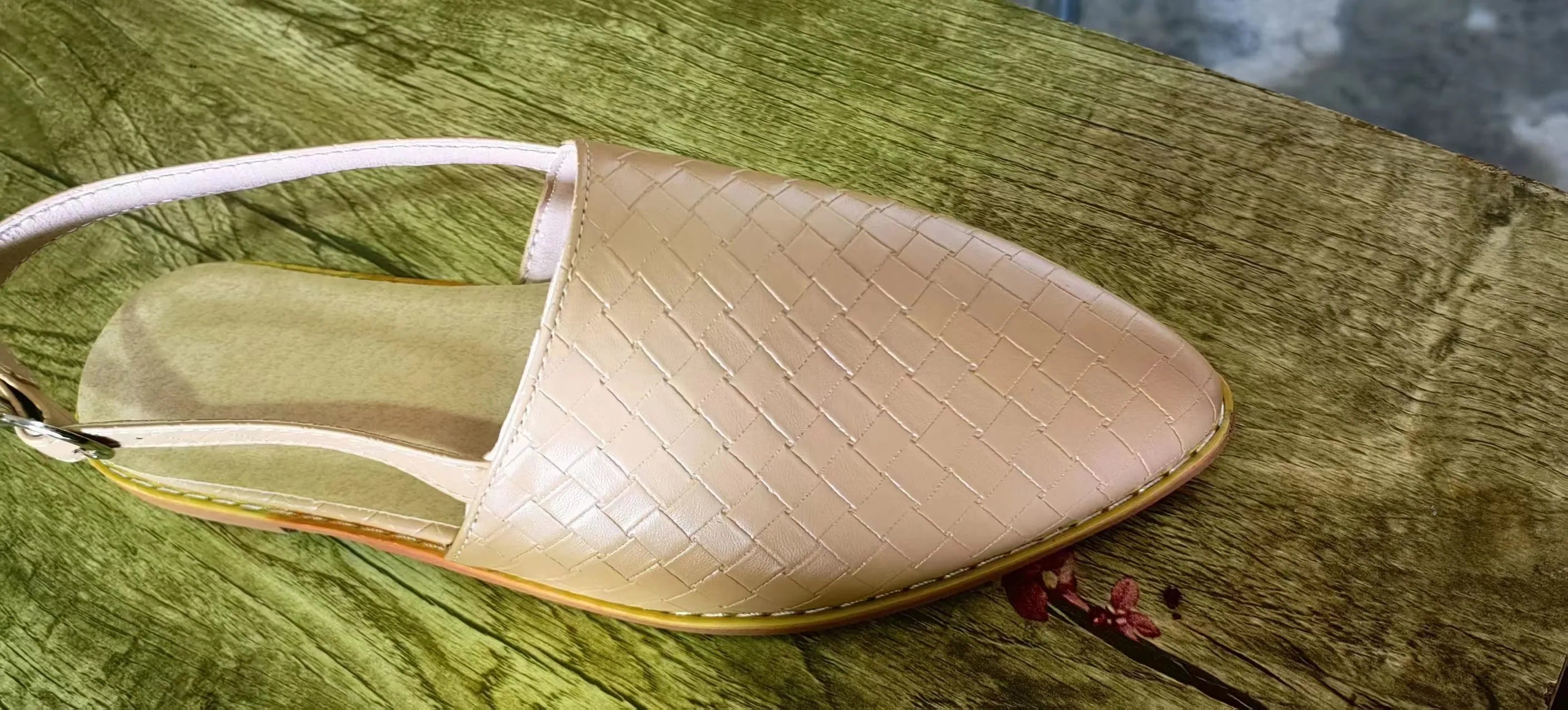 A pair of flat, pointed-toe sandals with a buckle fastening, shown in a choice of colours.