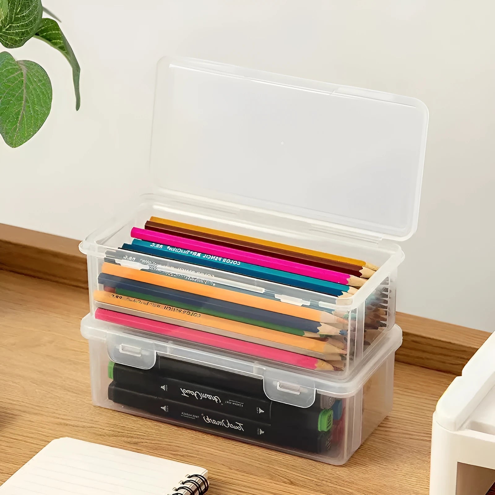 Transparent plastic pencil storage box showing organised drawing tools inside