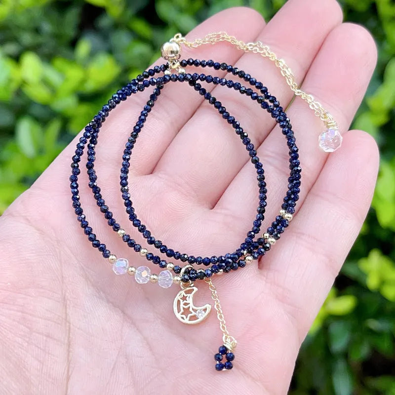 Women's multi-layer bracelet made of blue sand stone with three rings and gold-coloured accents.