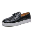 Men's black slip-on sneakers with a tassel detail on the round-toe upper.