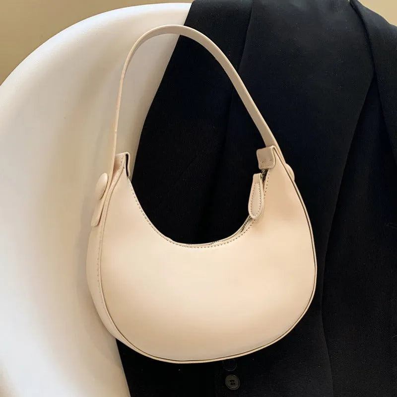 Women's retro dumpling-shaped shoulder bag in PU, shown in one of four colours, featuring an outer pocket and internal zipper compartment.