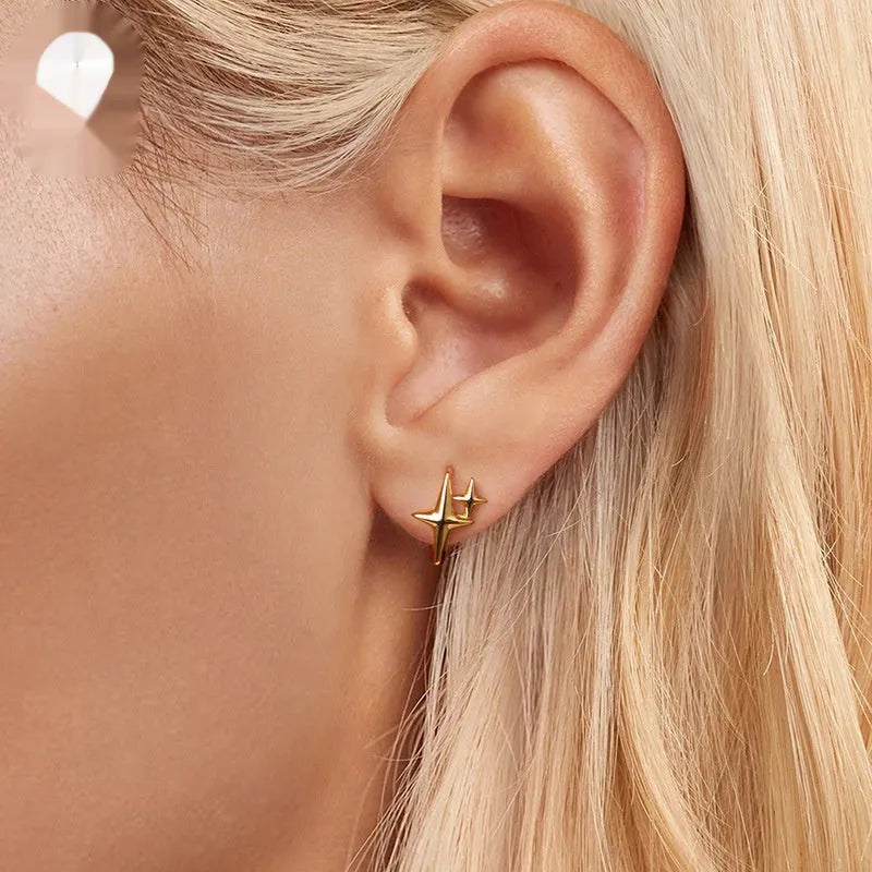 Minimalist silver star clip-on earrings with XINGX detail for women.