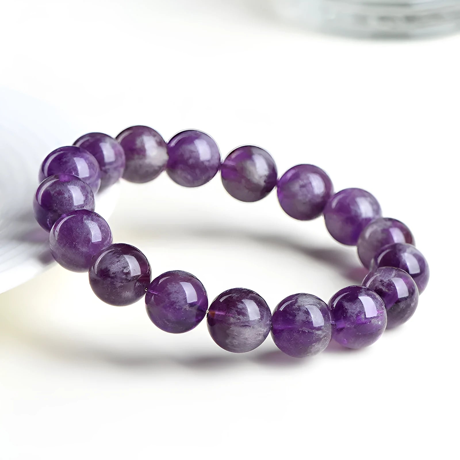 Natural purple feather amethyst crystal bracelet with geometric Ruyi design and scattered beads.