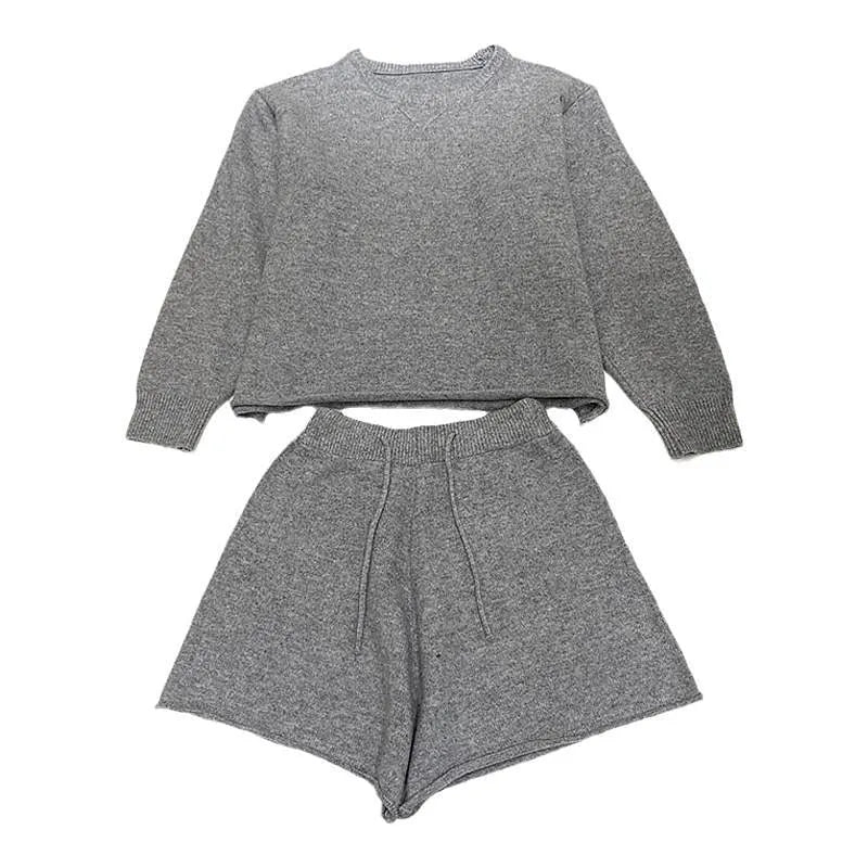 A woman's loose-fitting long sleeve knit sweater and matching wide-leg shorts set in a neutral colour.