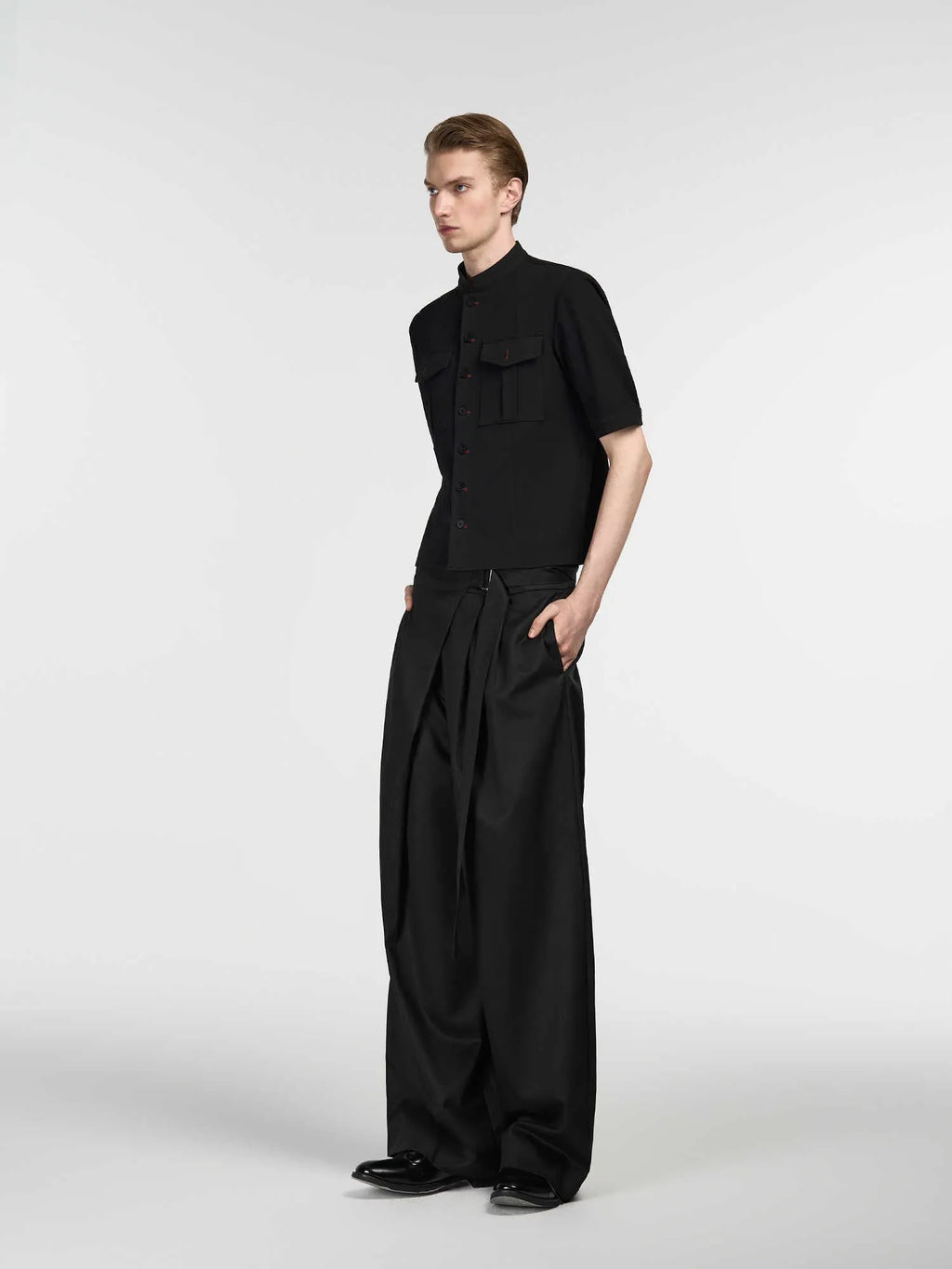 Black women's straight-leg trousers with a single pleat front and adjustable waistband on a hanger.