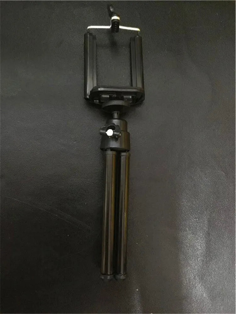 Black adjustable desktop phone holder with a two-section bracket on a wooden desk.