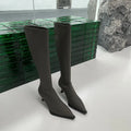 Black women's pointed toe below knee boots with a stiletto heel and a back zip.
