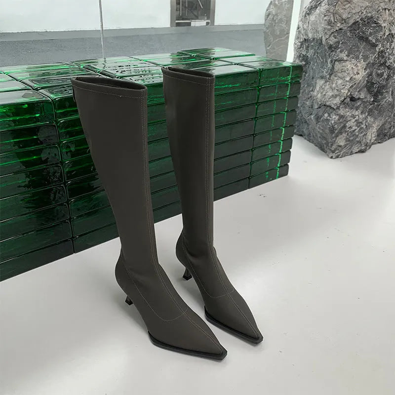 Black women's pointed toe below-the-knee boots with a stiletto heel and a back zipper.