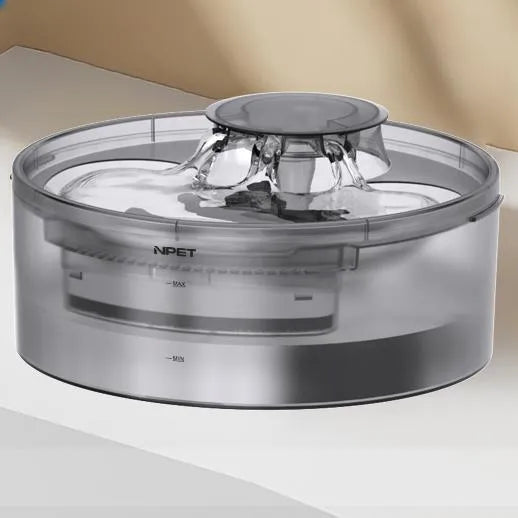 White automatic pet water fountain with flowing stream on a kitchen floor.