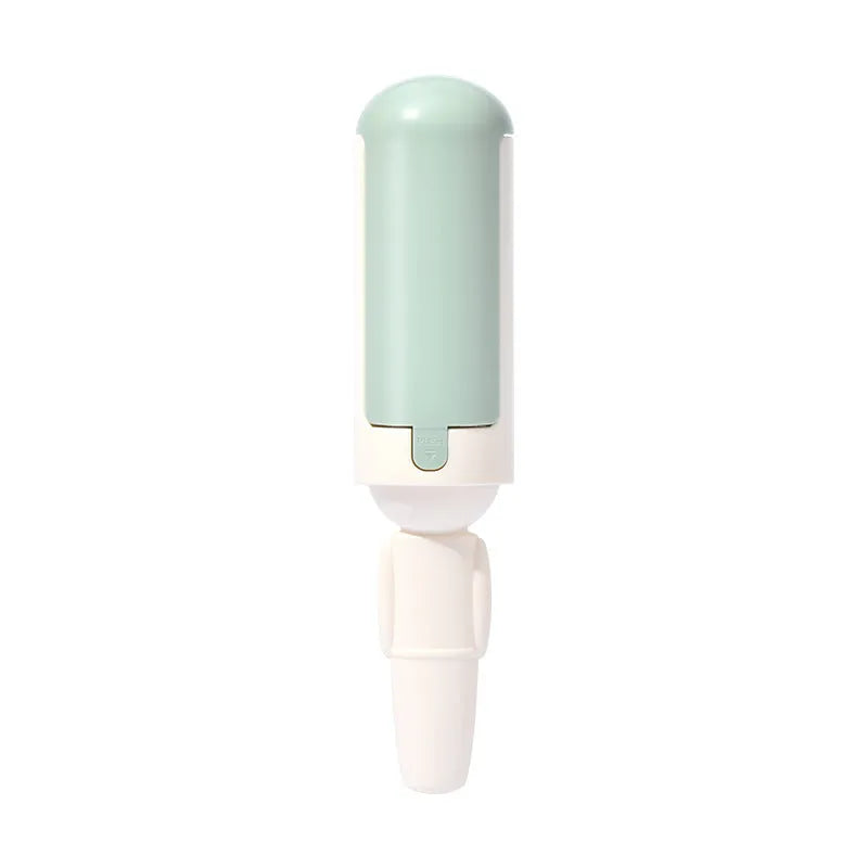 White and green reusable pet hair remover roller with a non-slip handle on a fabric sofa.