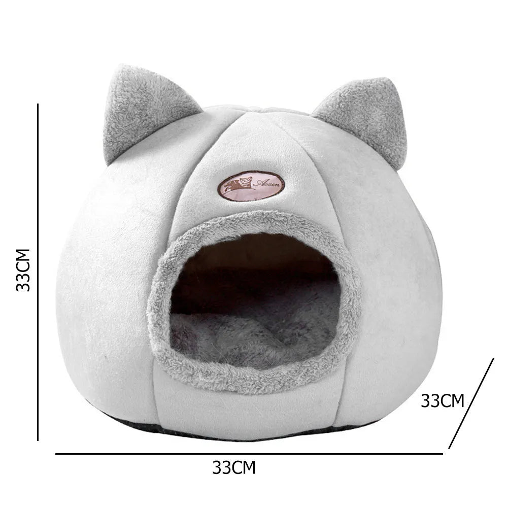 A fully enclosed cube-shaped cat sofa nest, showing the entrance hole, in a home setting.