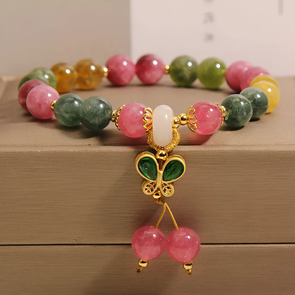 Women's bracelet with natural jade colour tourmaline butterfly pendant and rhinestone accents on alloy setting.