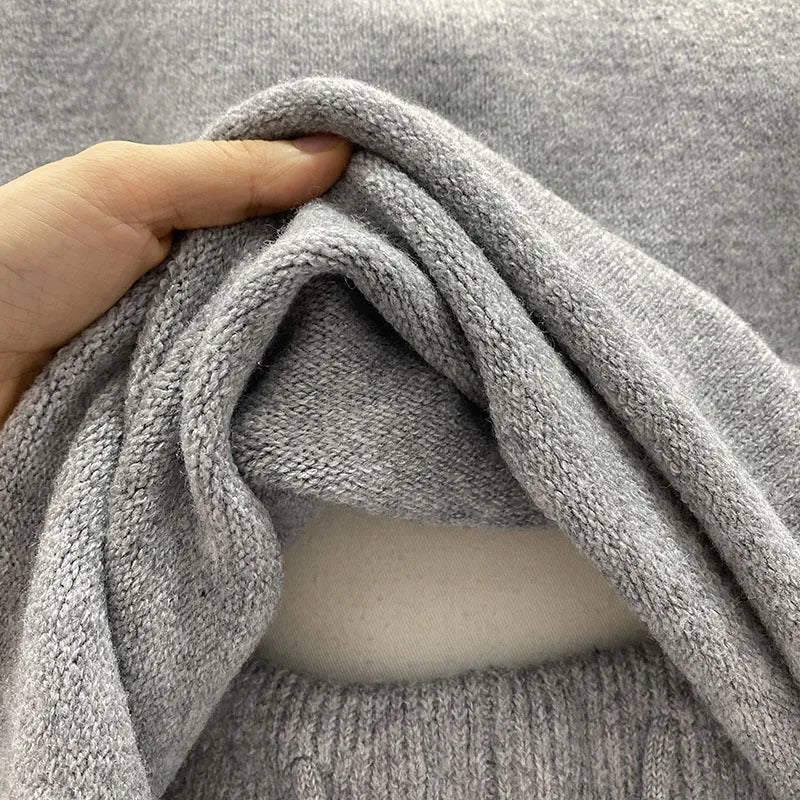 A woman's loose-fitting long sleeve knit sweater and matching wide-leg shorts set in a neutral colour.