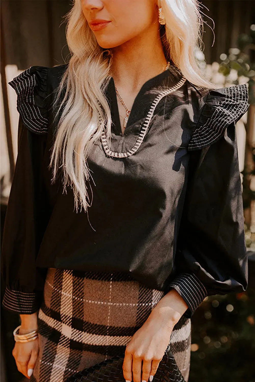 Black long sleeve V-neck blouse with ruffle detail and contrast stitching