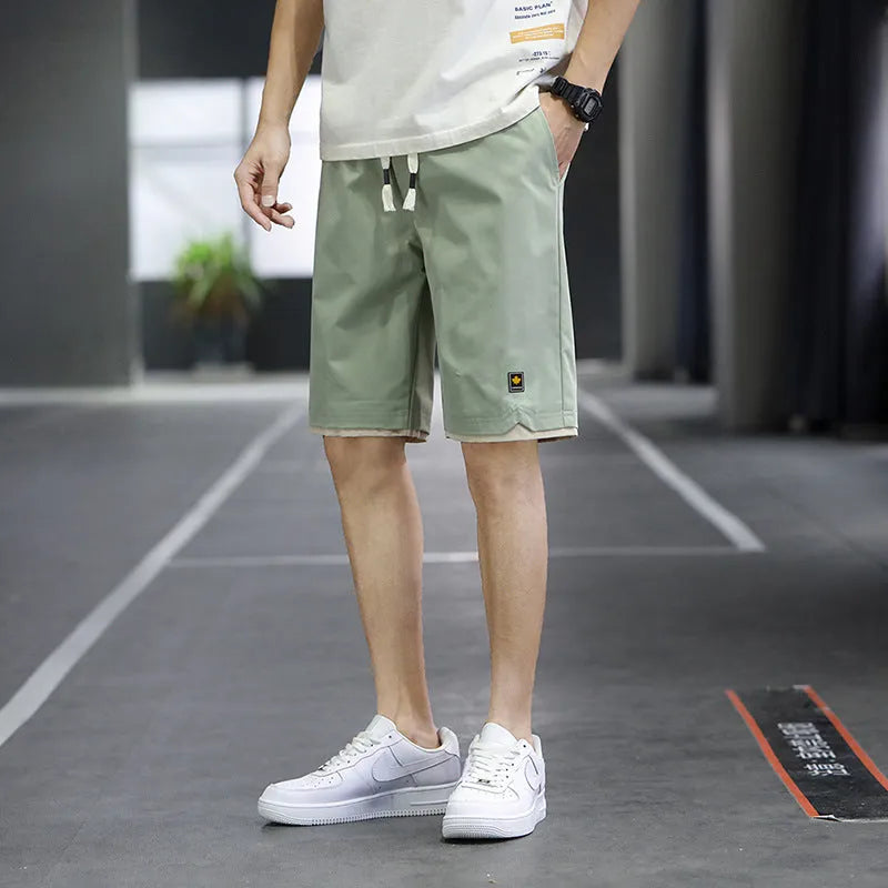 Man's loose-fit straight-leg casual shorts in green, shown for beachwear.