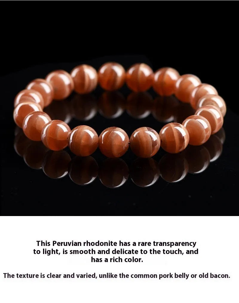 Natural old mine rhodochrosite bracelet with geometric beads and Ruyi symbols on a wrist.