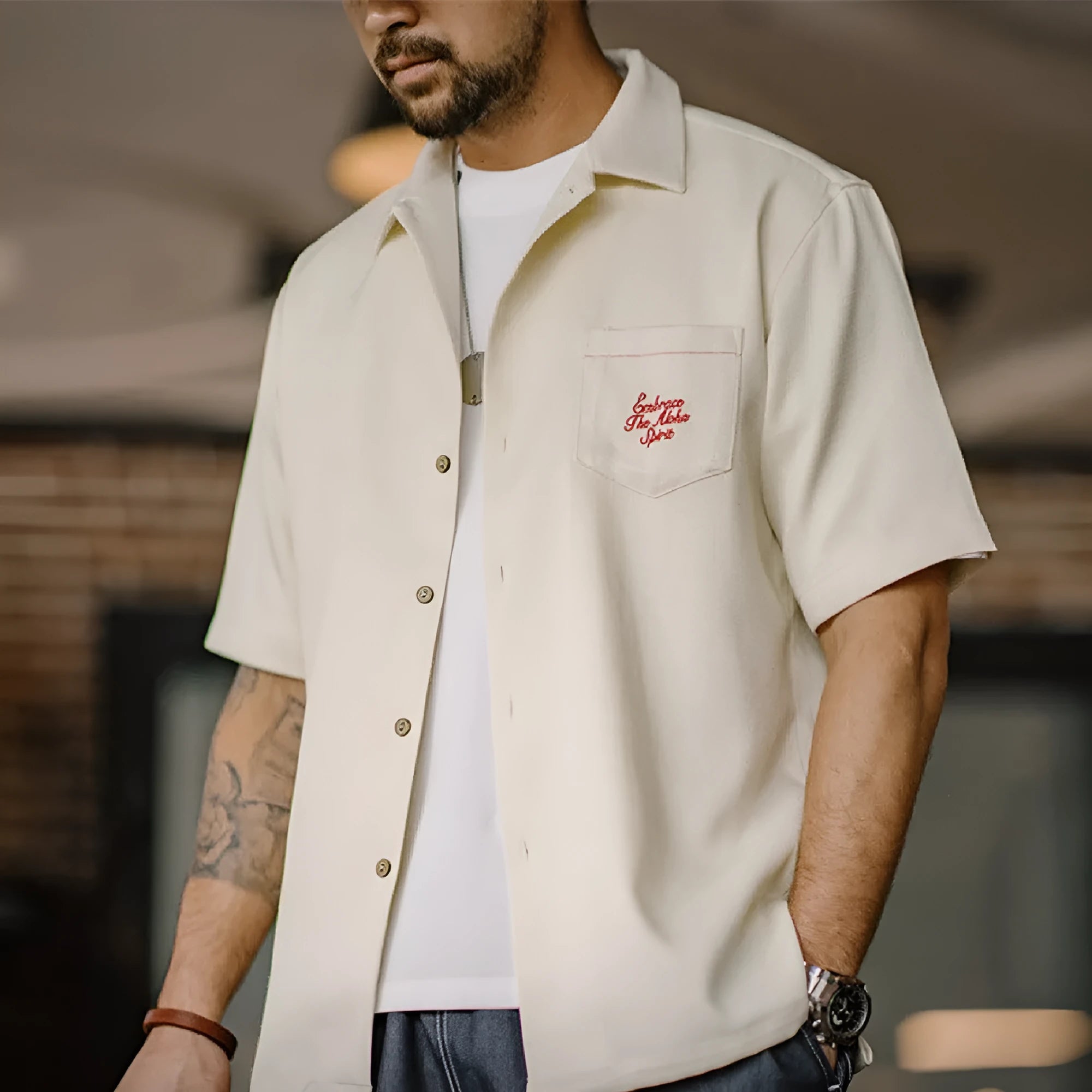 Light apricot men's shirt with bamboo and flower pattern, Cuban collar, on a hanger.