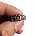 Close-up of a hand-forged copper Buddha ring with a grotto rock texture.