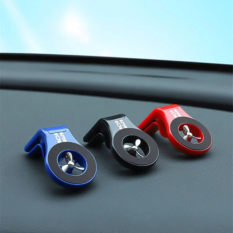 Black magnetic car phone holder with perfume slices, clipped on a car air vent