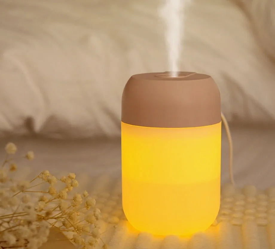 Small white cylindrical USB humidifier with charging cable for bedroom or desk use