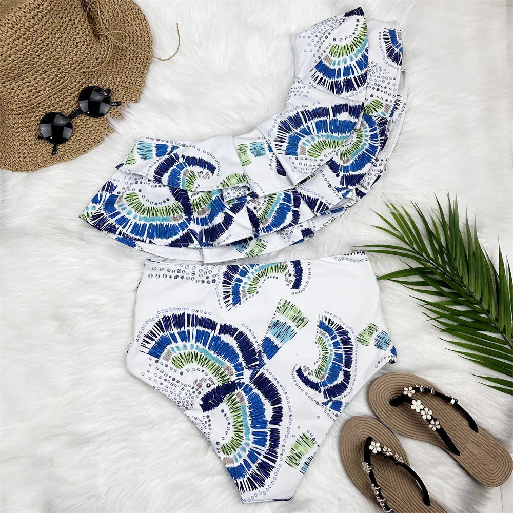 White women's one shoulder swimsuit with a layered lotus leaf skirt and a thigh high split.