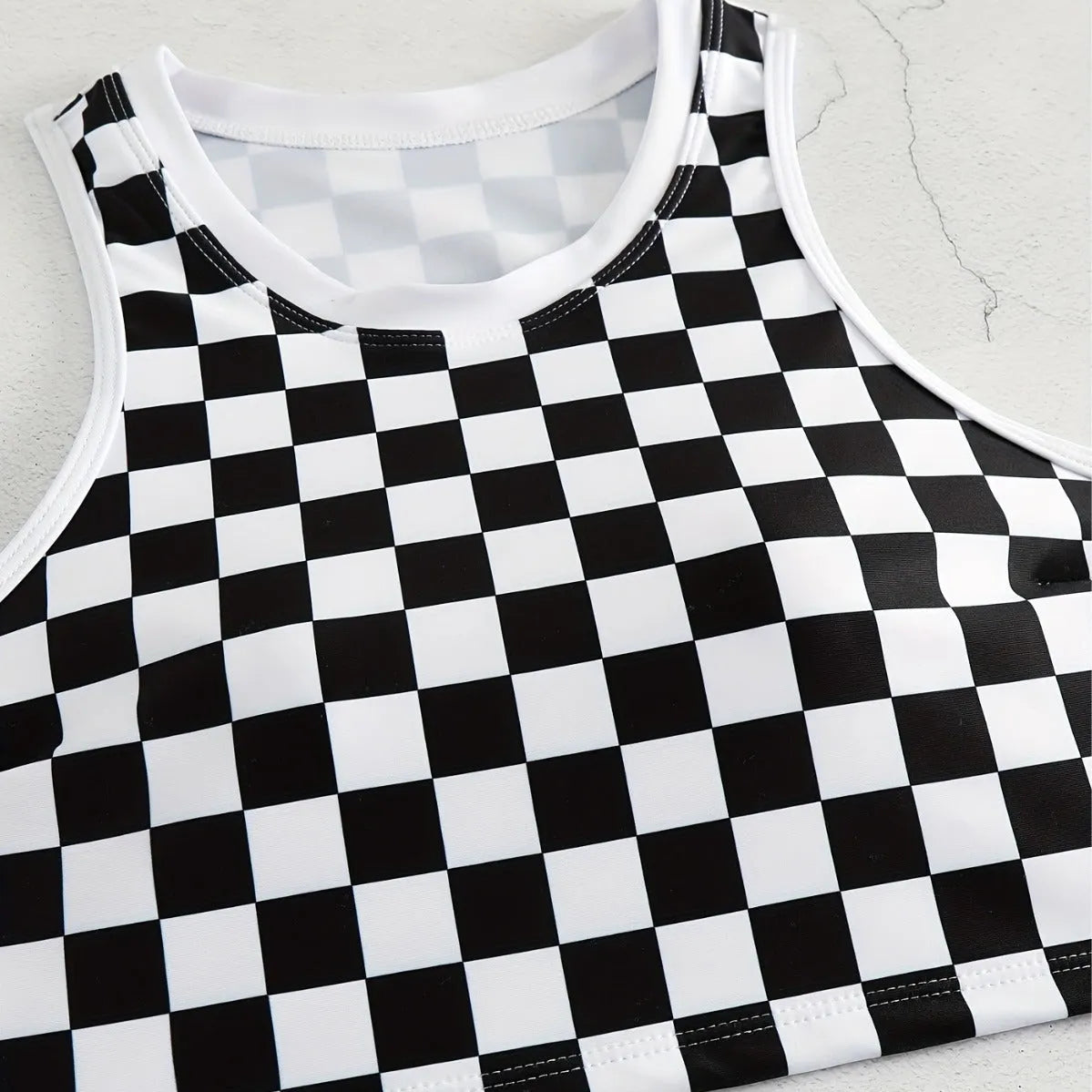 Women's black and white plaid racing one-piece swimsuit with backless design and adjustable suspender straps.