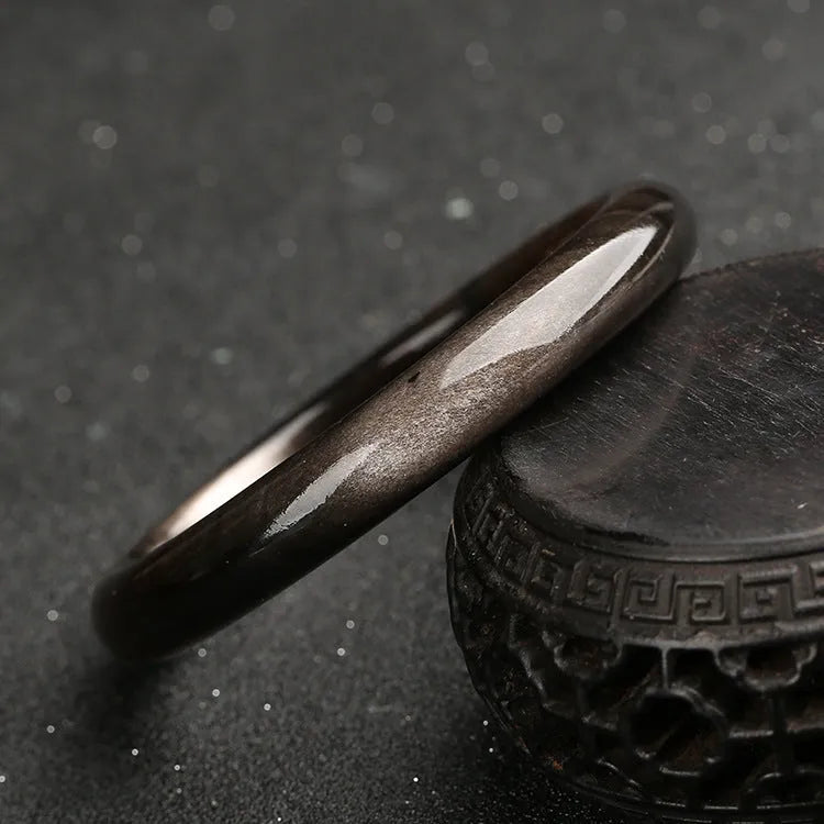 Silver stone cat's eye bracelet with ethnic geometric pattern on wrist.