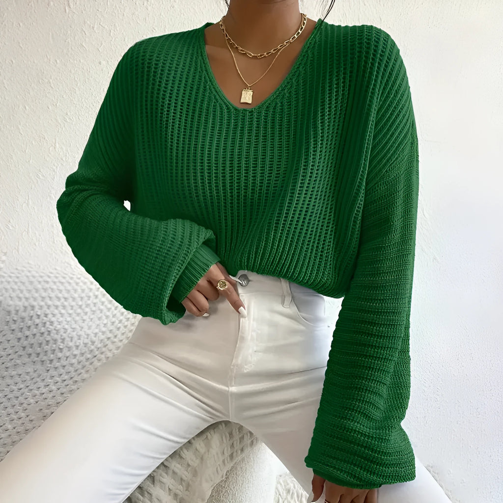 A woman's loose-fitting long sleeve pullover top in a solid colour.