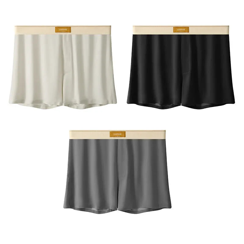 Three pairs of solid colour men's loose fit ice silk boxers laid flat, showing beige apricot, black, and dark grey.