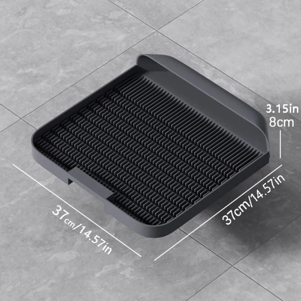 Large black cat litter pedal mat with textured grooves, placed next to a litter box.