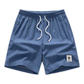 Man wearing grey straight leg drawstring summer shorts made from elastic fabric.