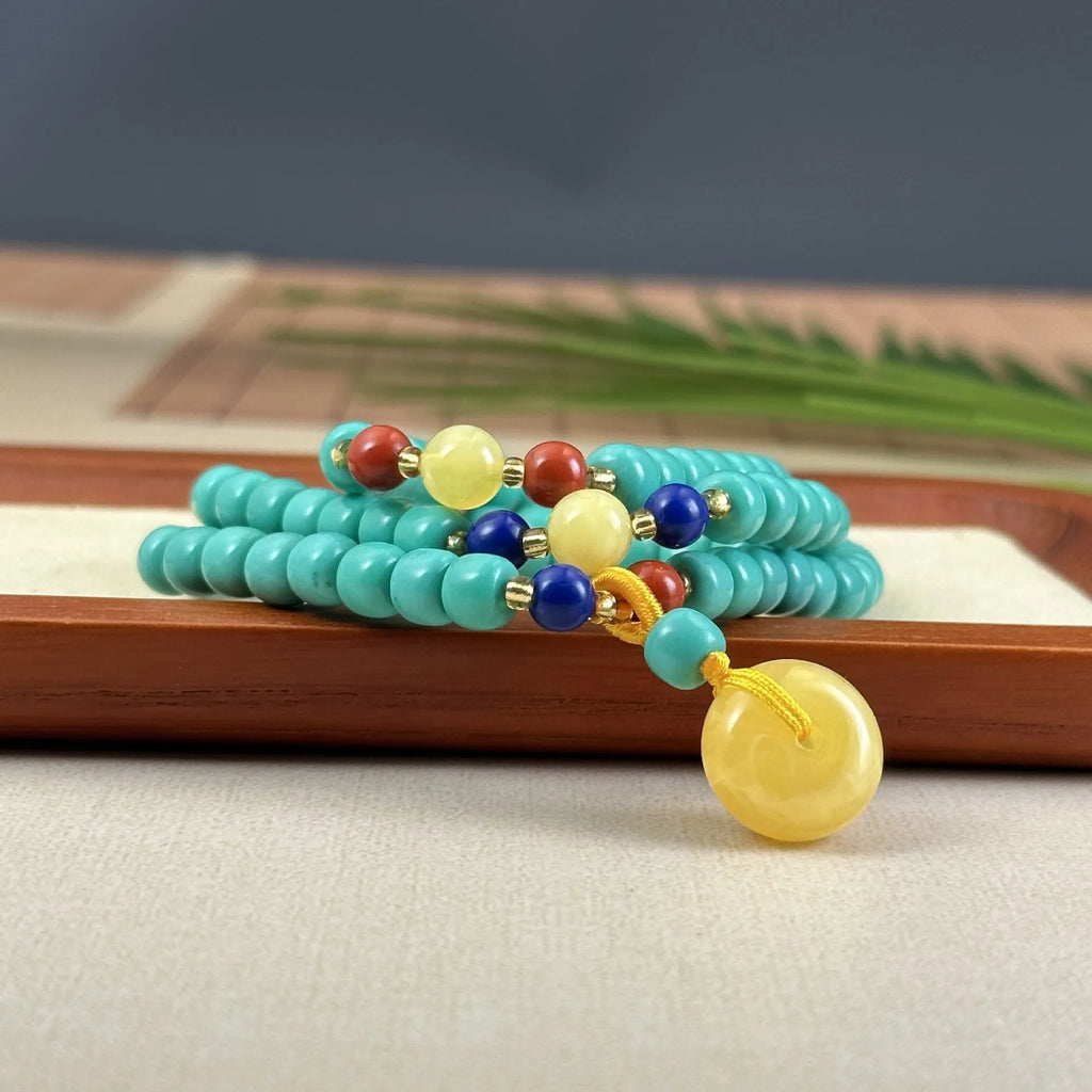 Turquoise hand-woven mesh flower lucky pendant on a long, adjustable ball bead necklace chain.