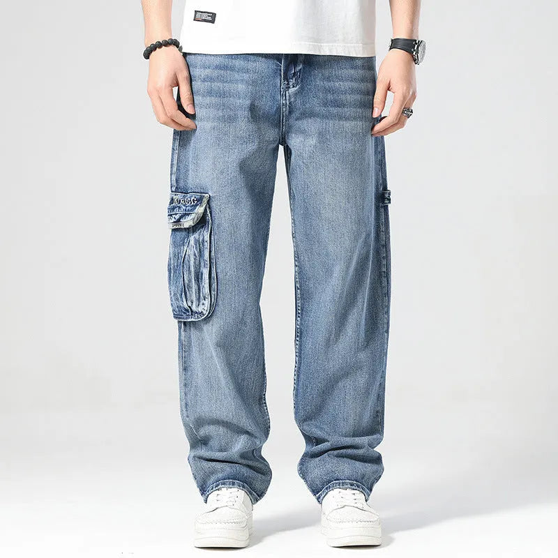Man wearing loose-fit blue denim hip hop trousers with multiple pockets and a straight leg.