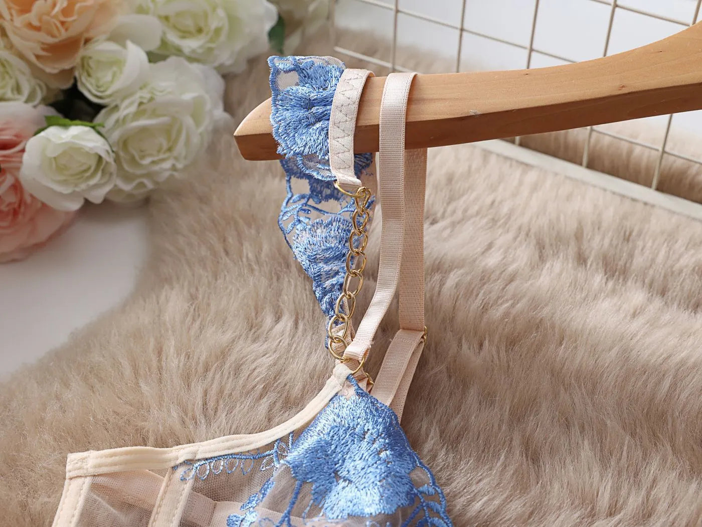 Light blue embroidered lace bra and matching briefs set on a plain background