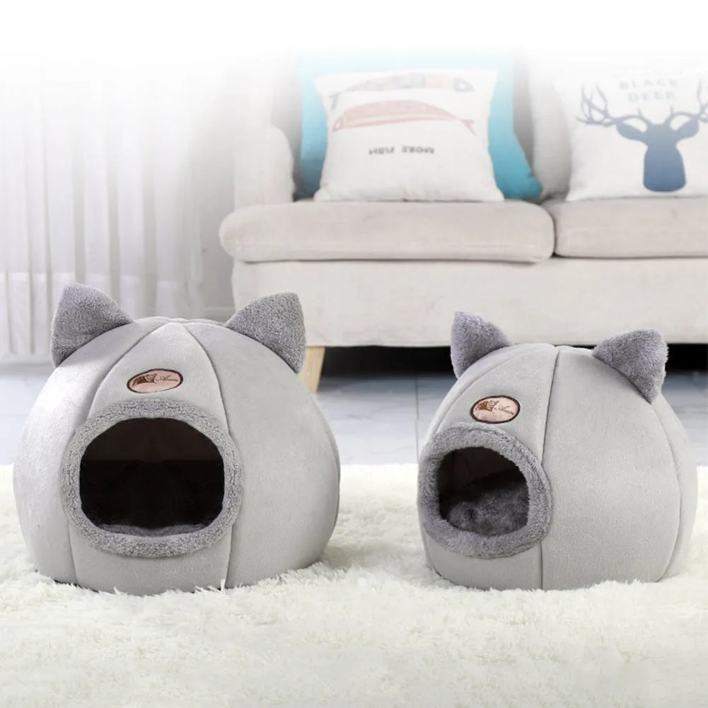 A fully enclosed cube-shaped cat sofa nest, showing the entrance hole, in a home setting.