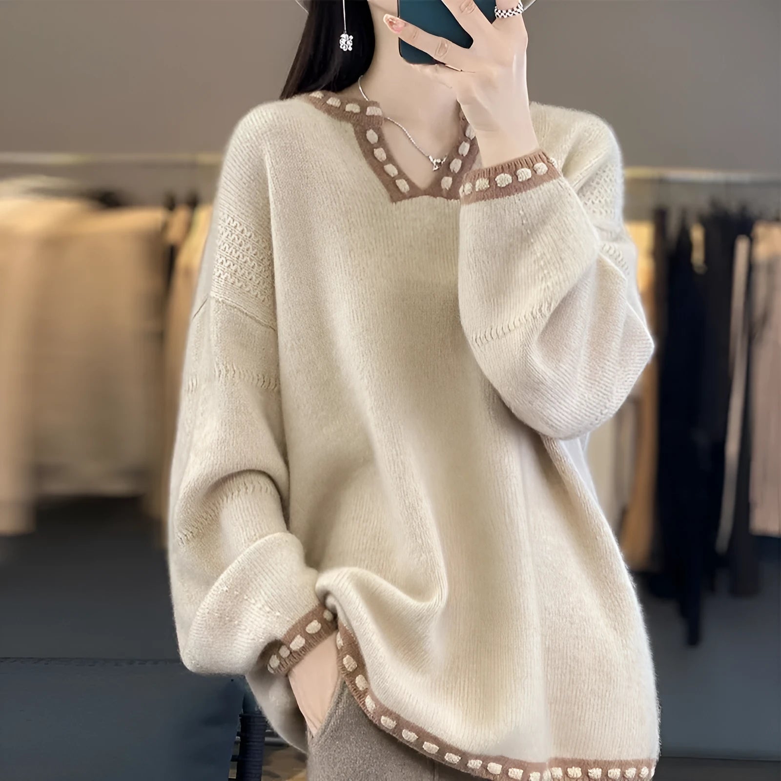 Women's camel coloured V-neck pullover sweater with long sleeves on hanger