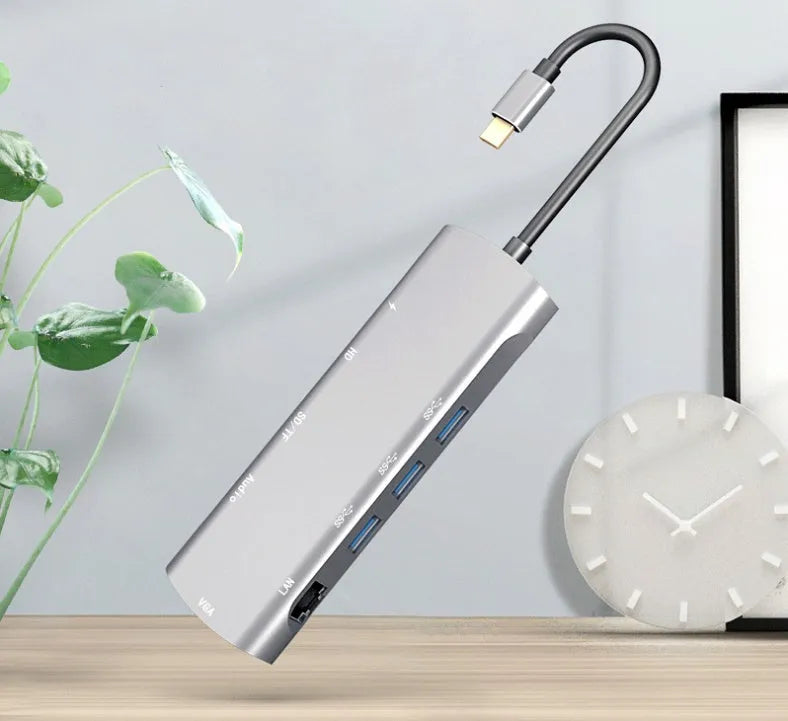 Grey aluminium USB-C docking station showing HDMI, VGA, USB, PD charging, and SD card ports.