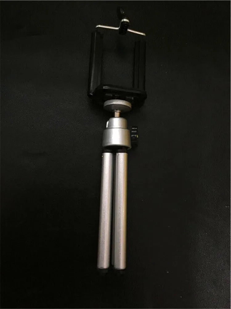 Black adjustable desktop phone holder with a two-section bracket on a wooden desk.