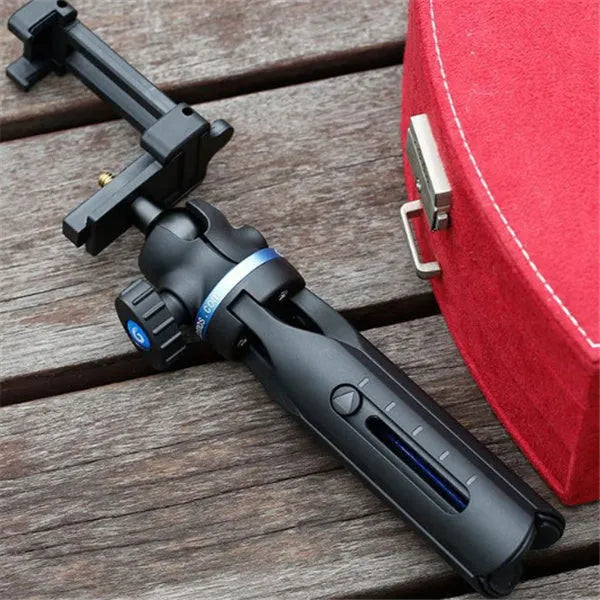 Black aluminium alloy and plastic desktop tripod stand holding a mobile phone.