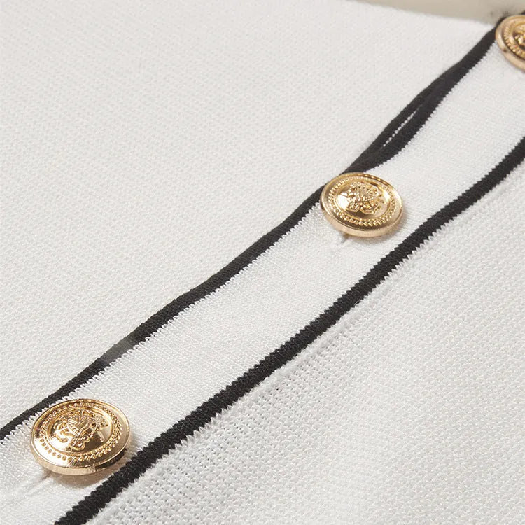 White short sleeve cardigan with dark contrast colour lapels on a hanger.