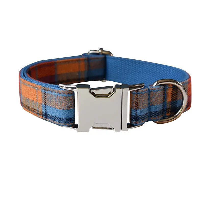 Blue background velvet plaid dog collar with a silver alloy metal buckle on a white surface.